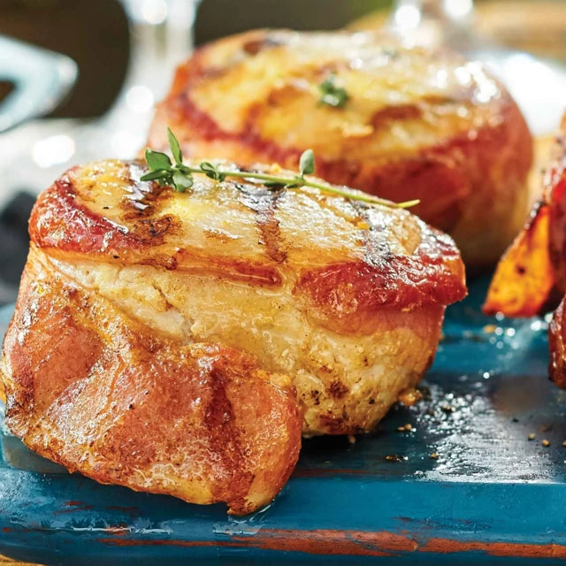 M&M meats bacon wrapped chicken on a blue plate.