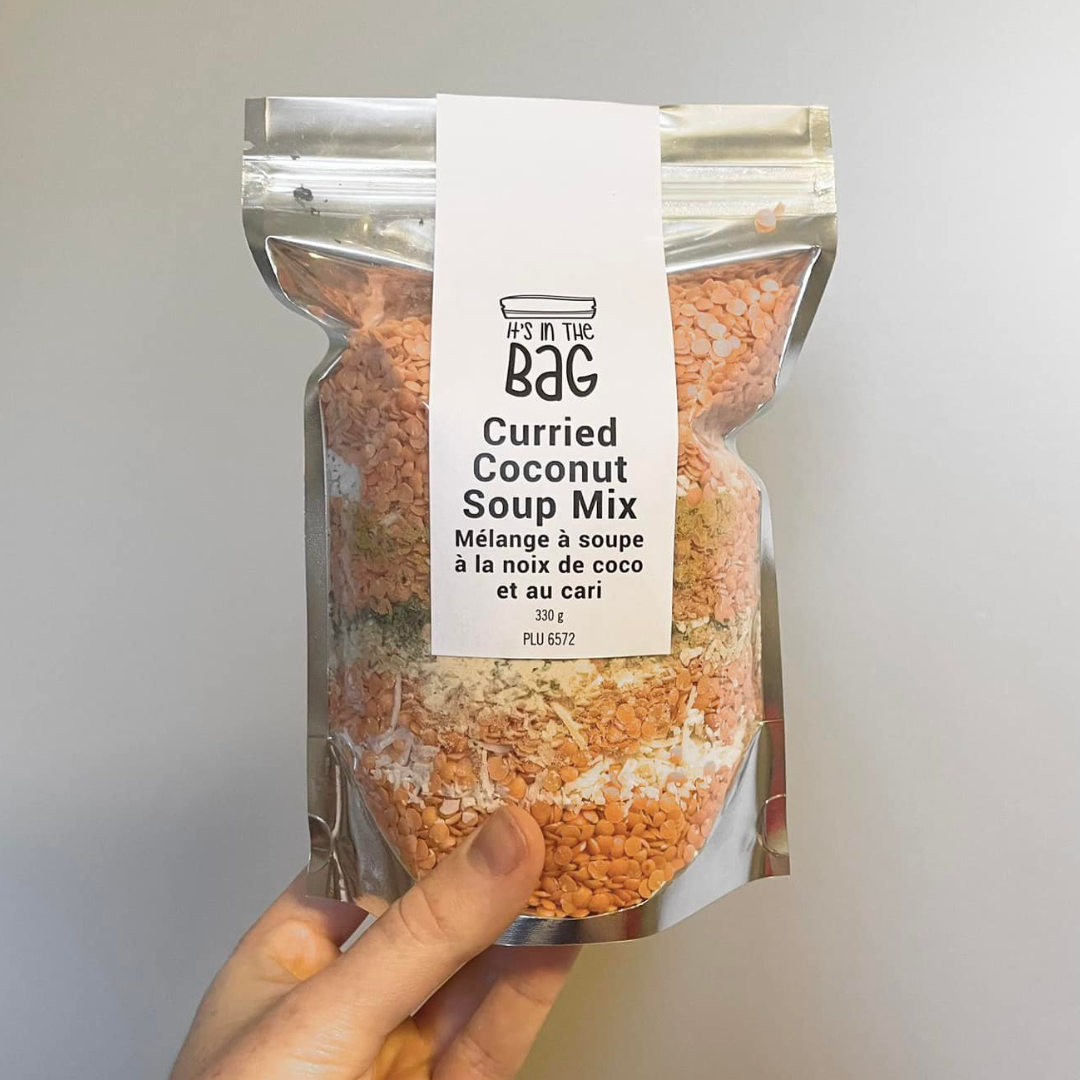 Curried Coconut Soup Mix package held by a hand against a gray background