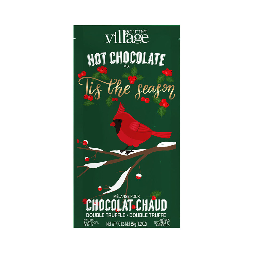 Gourmet Village hot chocolate mix packaging with a cardinal on a branch and red berries.