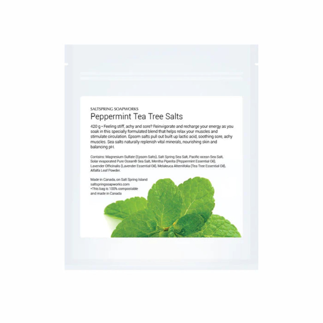 Product packaging with peppermint tea tree salts and green leaves on a white background